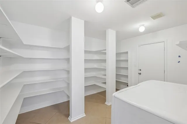 a room with a closet and wooden shelves