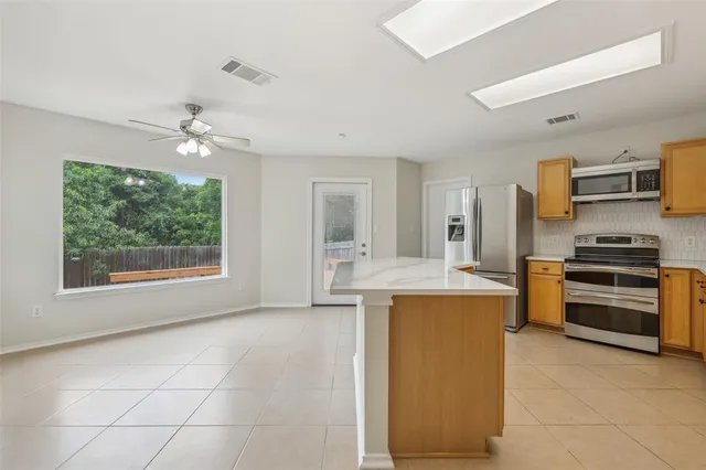 a kitchen with kitchen island granite countertop a stove and a refrigerator