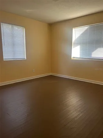 a view of a room that has wooden floor and windows in it