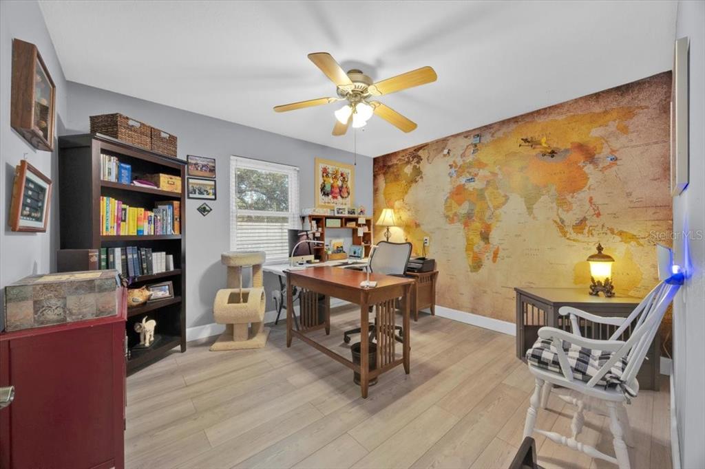 34159 Ridge Manor Boulevard Dade City, FL 33523 - Photo 14 of 33 a workspace with wooden floor and a bookshelf
