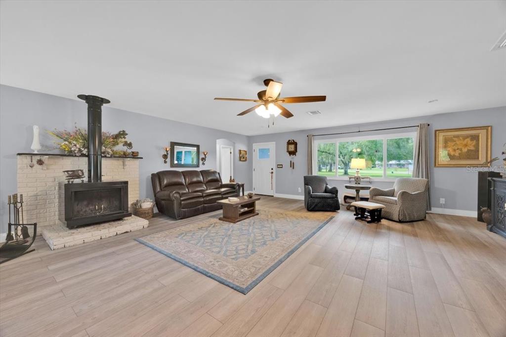 34159 Ridge Manor Boulevard Dade City, FL 33523 - Photo 4 of 33 a living room with furniture a fireplace and a flat screen tv