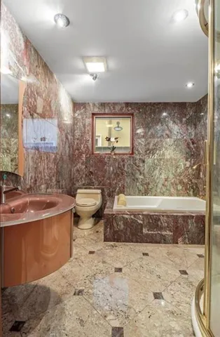 a bathroom with a toilet sink and mirror