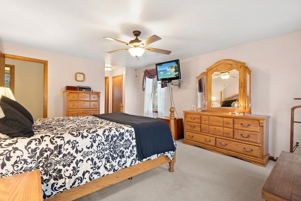 1 Beacon Hill Road Marblehead, MA 01945 - Photo 18 of 30 a bedroom with a bed and dresser with mirror