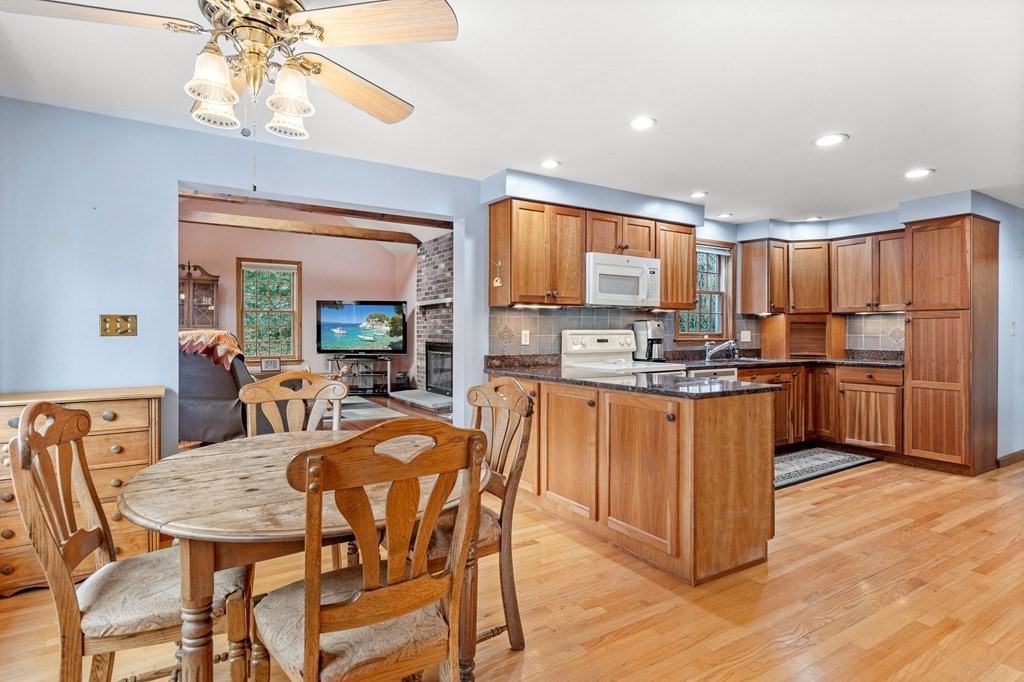 1 Beacon Hill Road Marblehead, MA 01945 - Photo 8 of 30 a kitchen with stainless steel appliances kitchen island granite countertop a refrigerator a stove top oven and a dining table with wooden floor