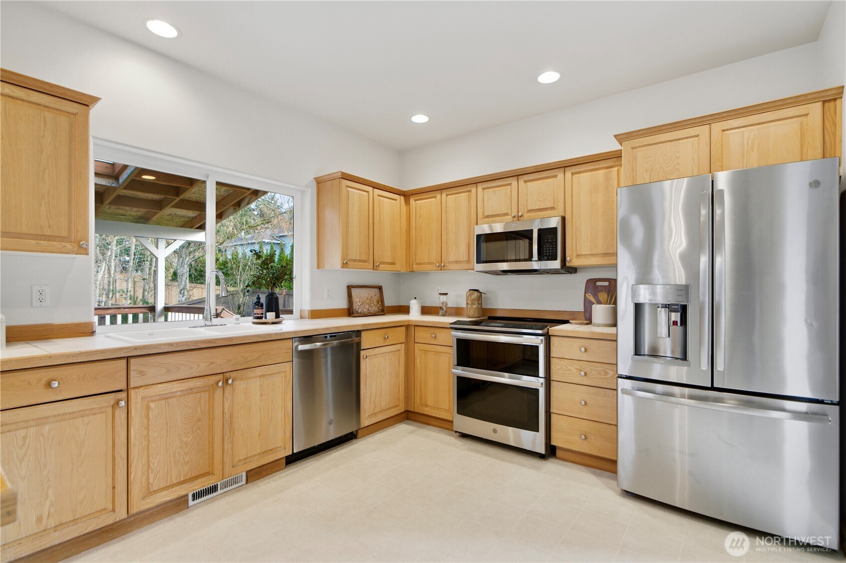 1611 242nd Street Southeast Bothell, WA 98021 - Photo 14 of 39 a kitchen with white cabinets stainless steel appliances and a window