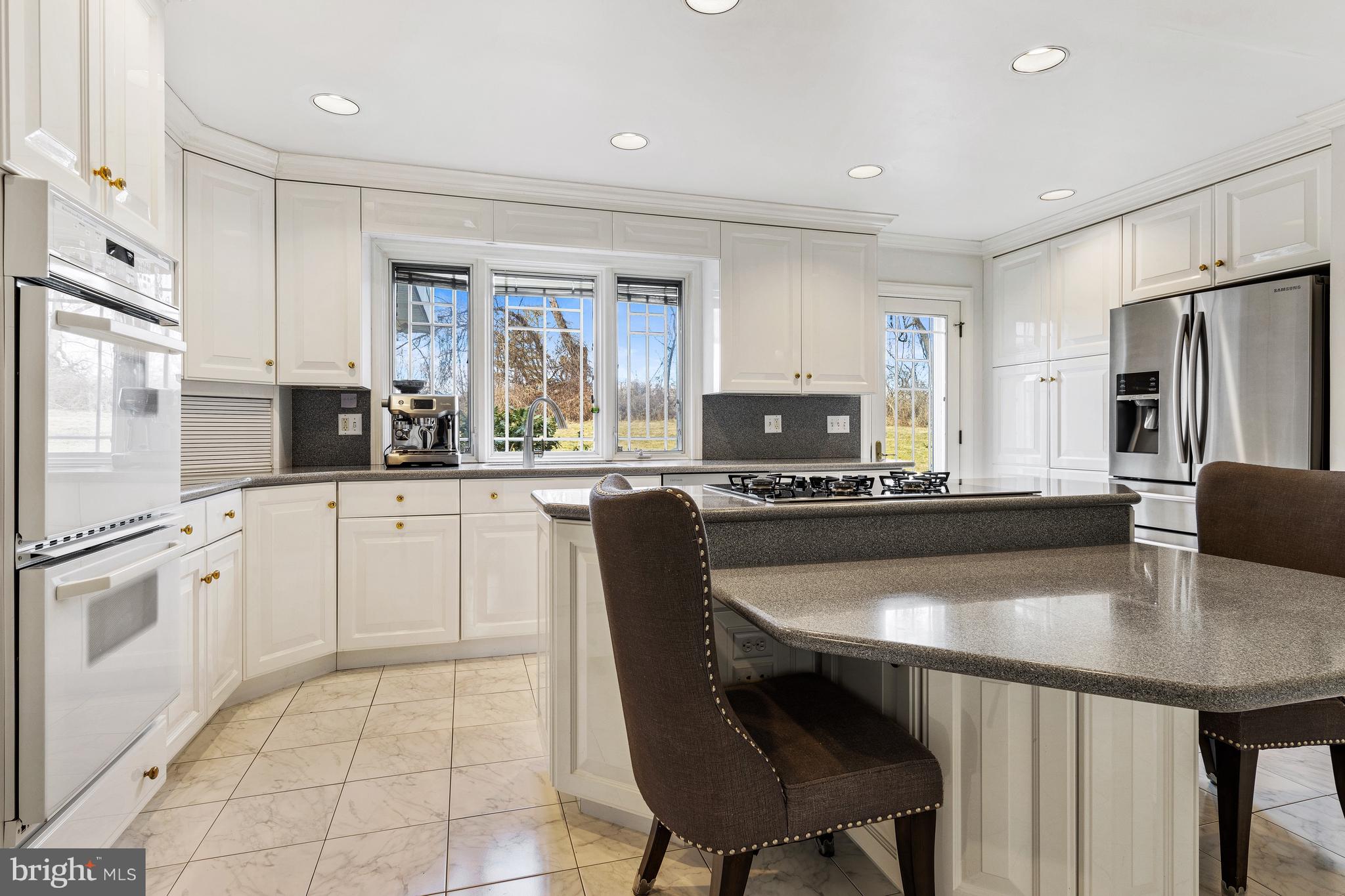 5004 Kennett Pike Wilmington, DE 19807 - Photo 14 of 37 a kitchen with stainless steel appliances granite countertop a table chairs microwave and sink