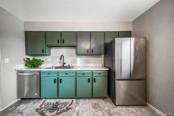 a kitchen with stainless steel appliances granite countertop a refrigerator and a sink