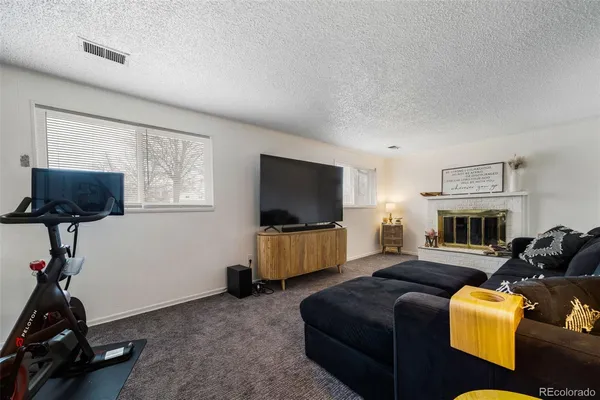 a living room with furniture a flat screen tv and a window
