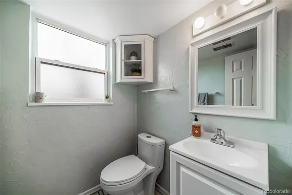 a bathroom with a sink a toilet and a mirror