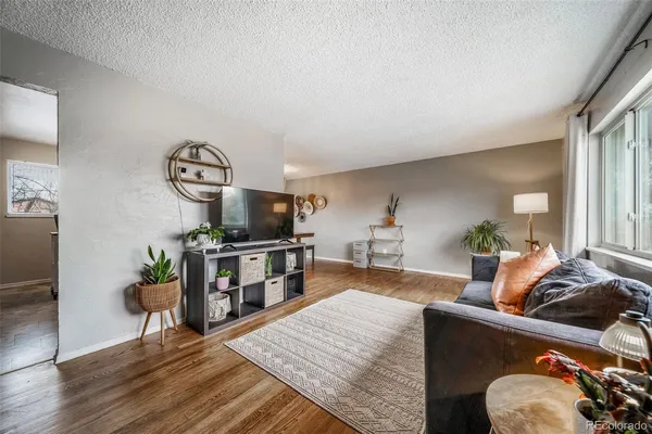 a living room with furniture and a wooden floor