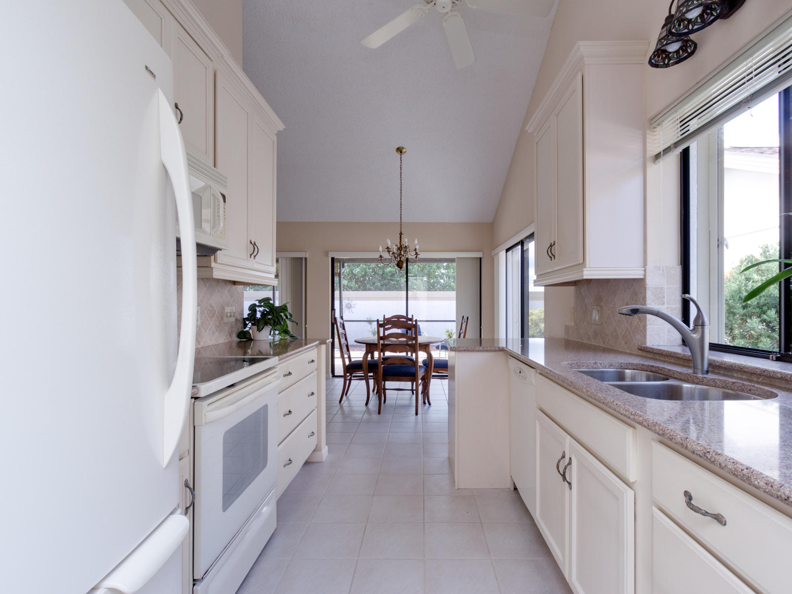 186 Ridge Road Jupiter, FL 33477 - Photo 15 of 44 a kitchen with granite countertop white cabinets and white appliances