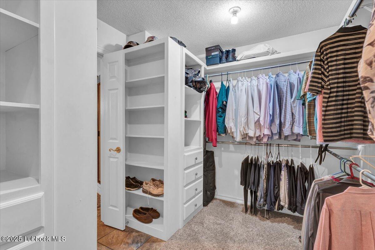 7206 76th Street Lubbock, TX 79407 - Photo 21 of 55 a view of walk in closet with clothes and shoes