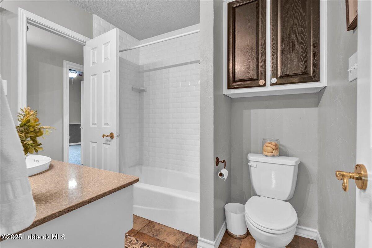 7206 76th Street Lubbock, TX 79407 - Photo 29 of 55 a bathroom with a toilet a sink and bathtub