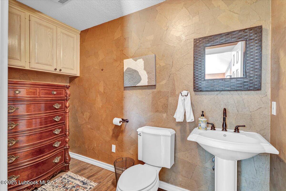 7206 76th Street Lubbock, TX 79407 - Photo 34 of 55 a bathroom with a sink a toilet and mirror