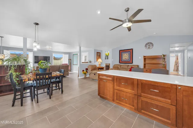 a view of a dining room and livingroom with furniture wooden floor a rug a flat screen tv