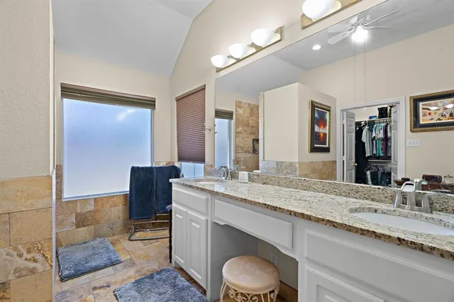 a bathroom with a granite countertop sink a toilet and a mirror