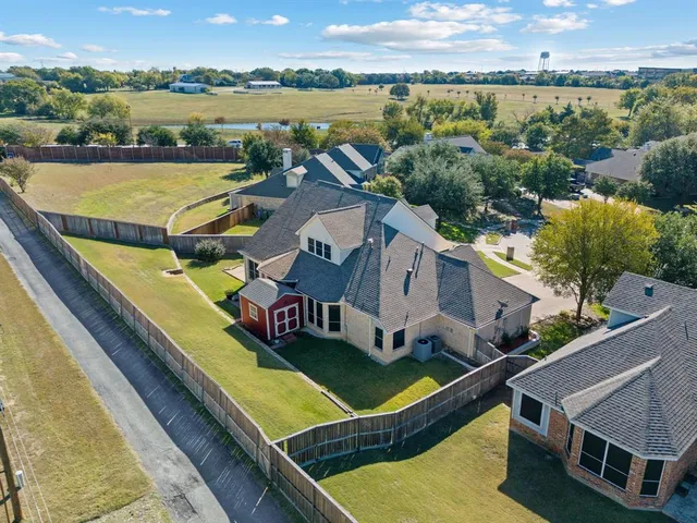 an aerial view of residential houses with outdoor space and lake view