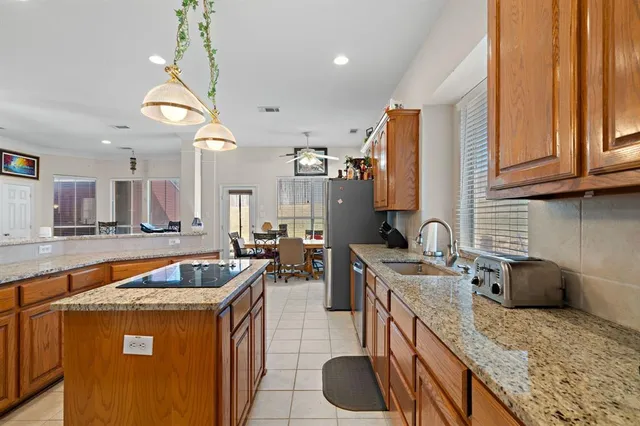 a kitchen with stainless steel appliances granite countertop a sink a stove and a wooden floors