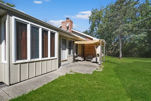 a view of a house with a yard and sitting area