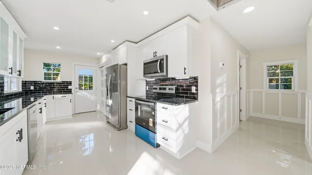 a kitchen with stainless steel appliances a stove microwave and refrigerator
