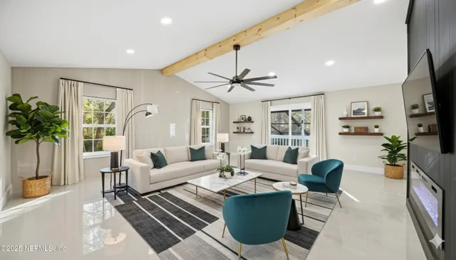 a living room with furniture a chandelier and a flat screen tv