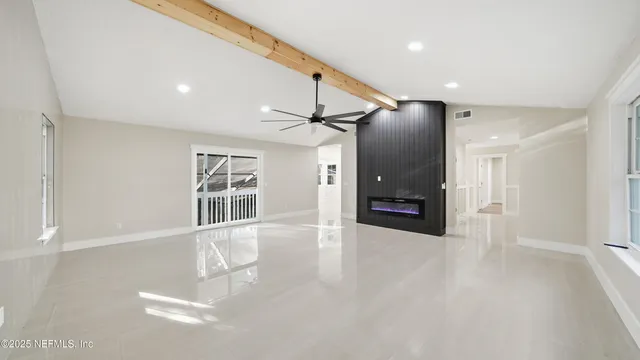 a view of a hallway with wooden floor and a living room