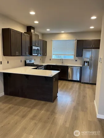 a kitchen with stainless steel appliances granite countertop a stove a sink and a refrigerator