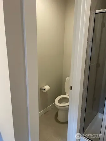 a bathroom with a granite countertop toilet and a sink