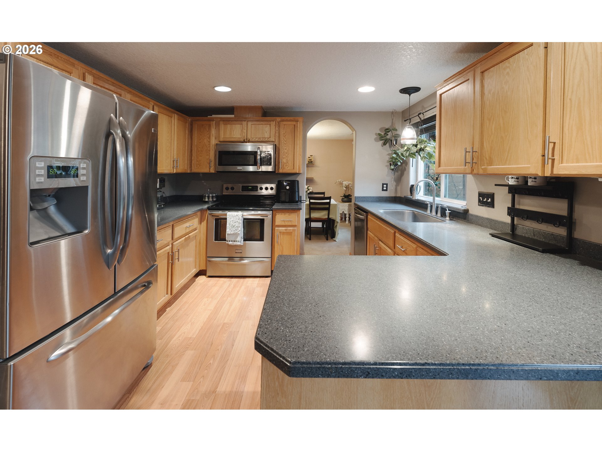 1254 Crystal Lane Lafayette, OR 97127 - Photo 5 of 34 a kitchen with stainless steel appliances granite countertop a refrigerator a stove and a sink with wooden floor