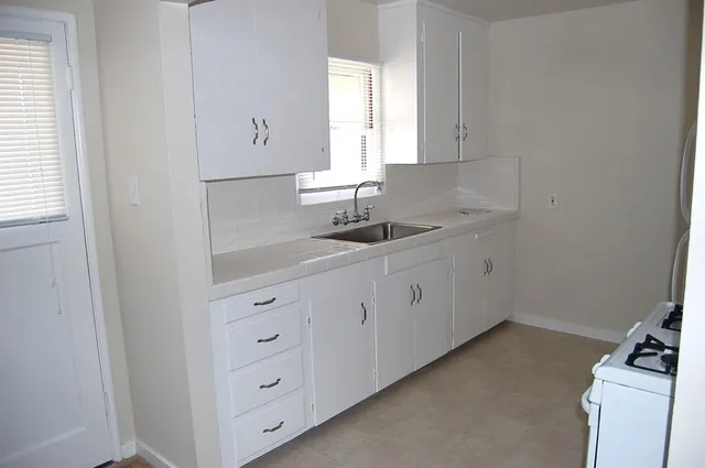 a white refrigerator freezer and a stove sitting inside of a kitchen