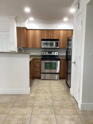 a kitchen with stainless steel appliances a stove a sink and a refrigerator