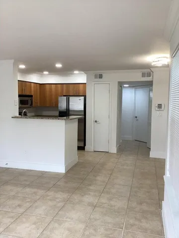 a view of kitchen with refrigerator and microwave
