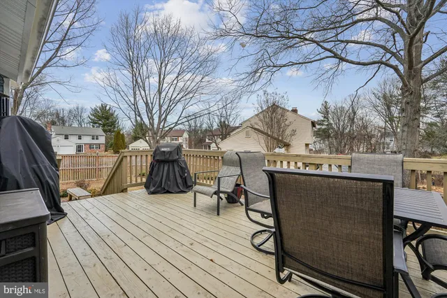 a view of a house with wooden deck and trees