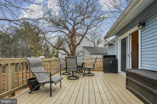 a view of a roof deck with table and chairs wooden floor and fence