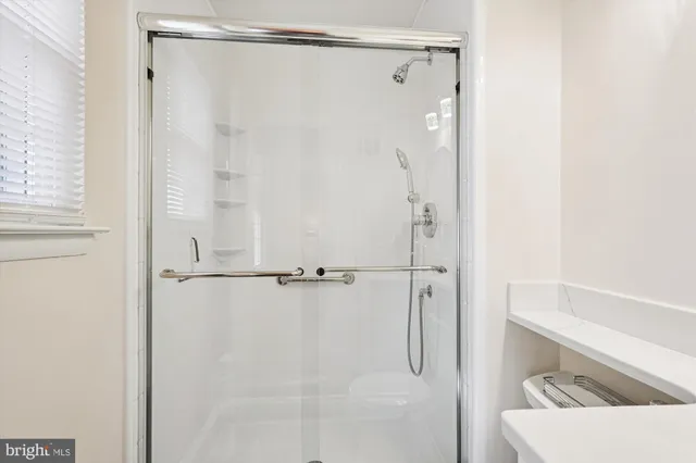 a bathroom with a shower and a glass door