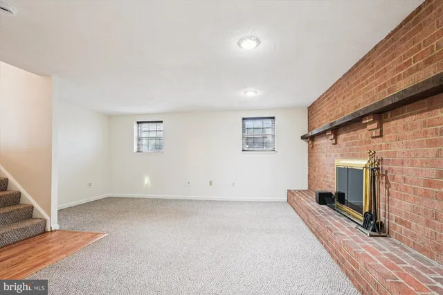 a view of an empty room with a fireplace and a window