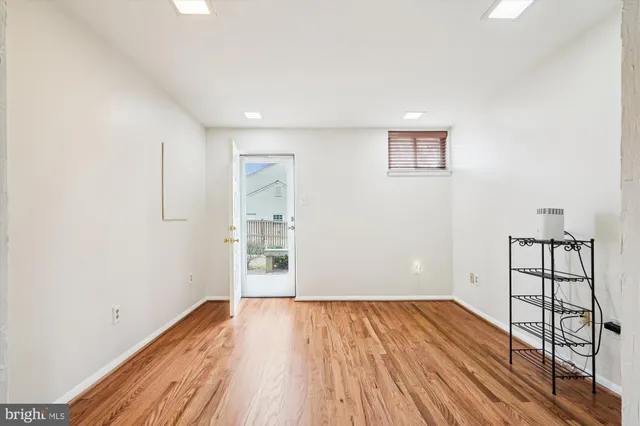 an empty room with wooden floor and a window
