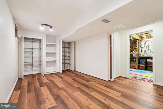 a view of empty room with wooden floor and cabinet