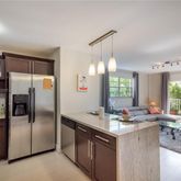 a kitchen with stainless steel appliances granite countertop a sink refrigerator and window