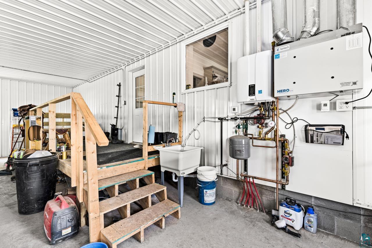 33415 Jackson Road Askov, MN 55704 - Photo 13 of 91 Garage featuring tankless water heater and metal wall