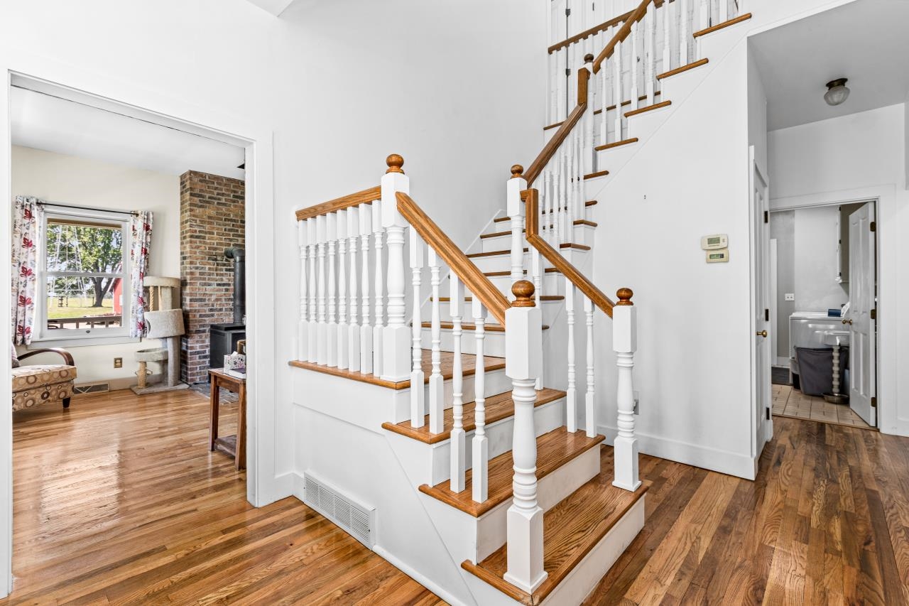 33415 Jackson Road Askov, MN 55704 - Photo 25 of 91 Staircase with wood finished floors and a wood stove