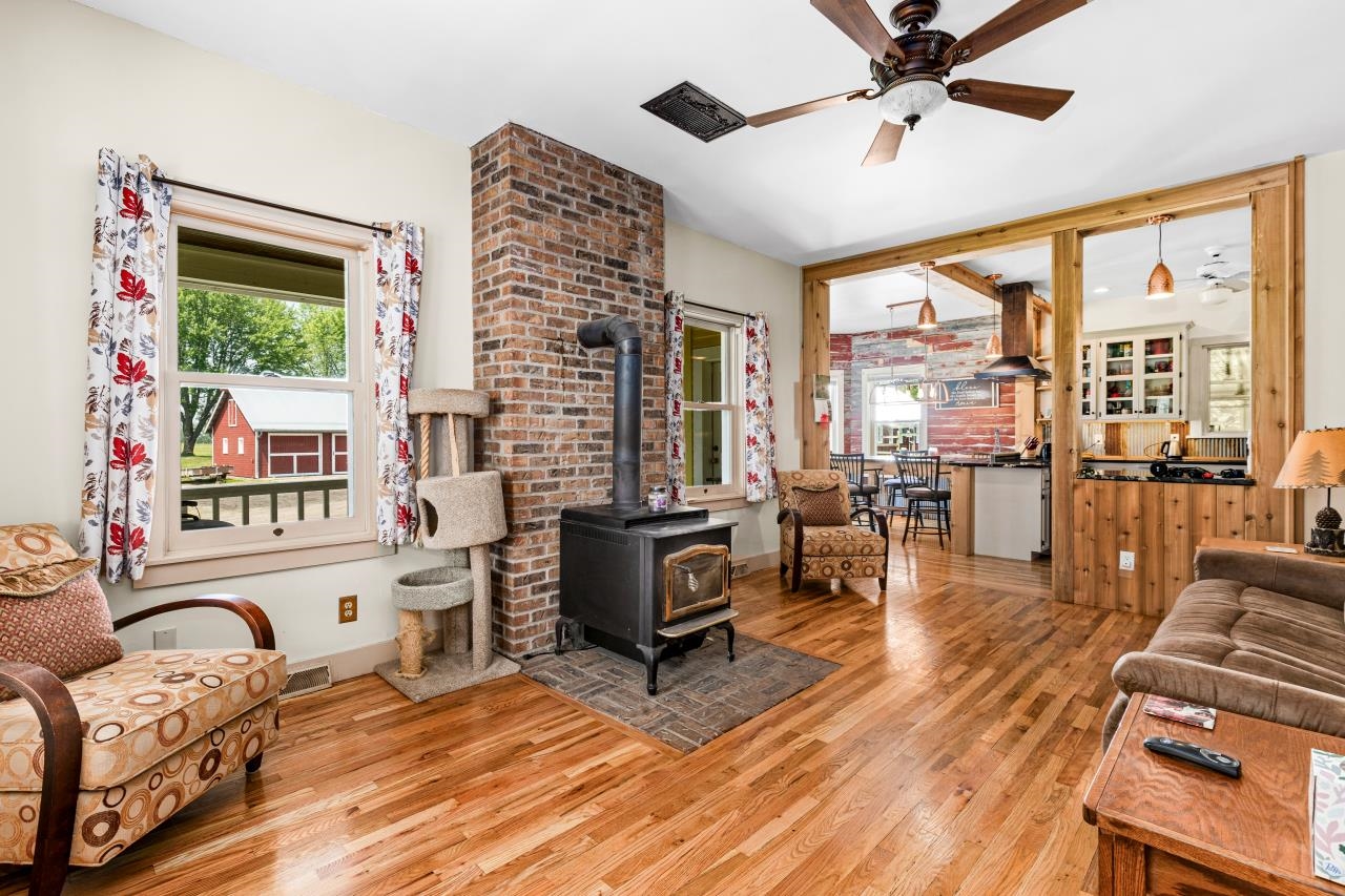 33415 Jackson Road Askov, MN 55704 - Photo 31 of 91 Living room with wood finished floors, a wood stove, and ceiling fan
