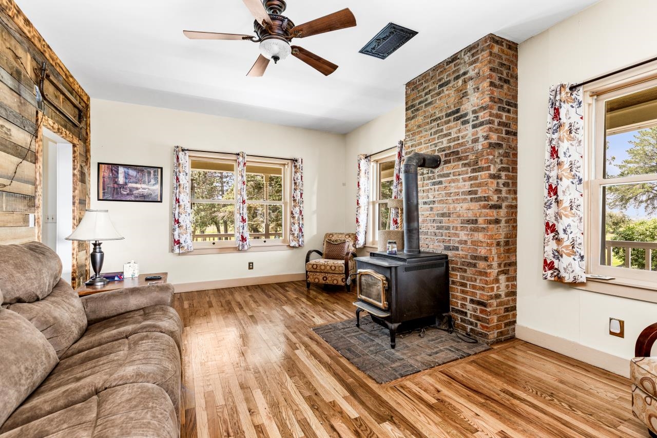 33415 Jackson Road Askov, MN 55704 - Photo 33 of 91 Living room with wood finished floors, a wood stove, and a ceiling fan
