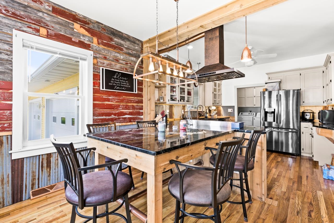 33415 Jackson Road Askov, MN 55704 - Photo 36 of 91 Kitchen featuring washer and clothes dryer, stainless steel fridge with ice dispenser, a ceiling fan, dark countertops, and dark wood finished floors