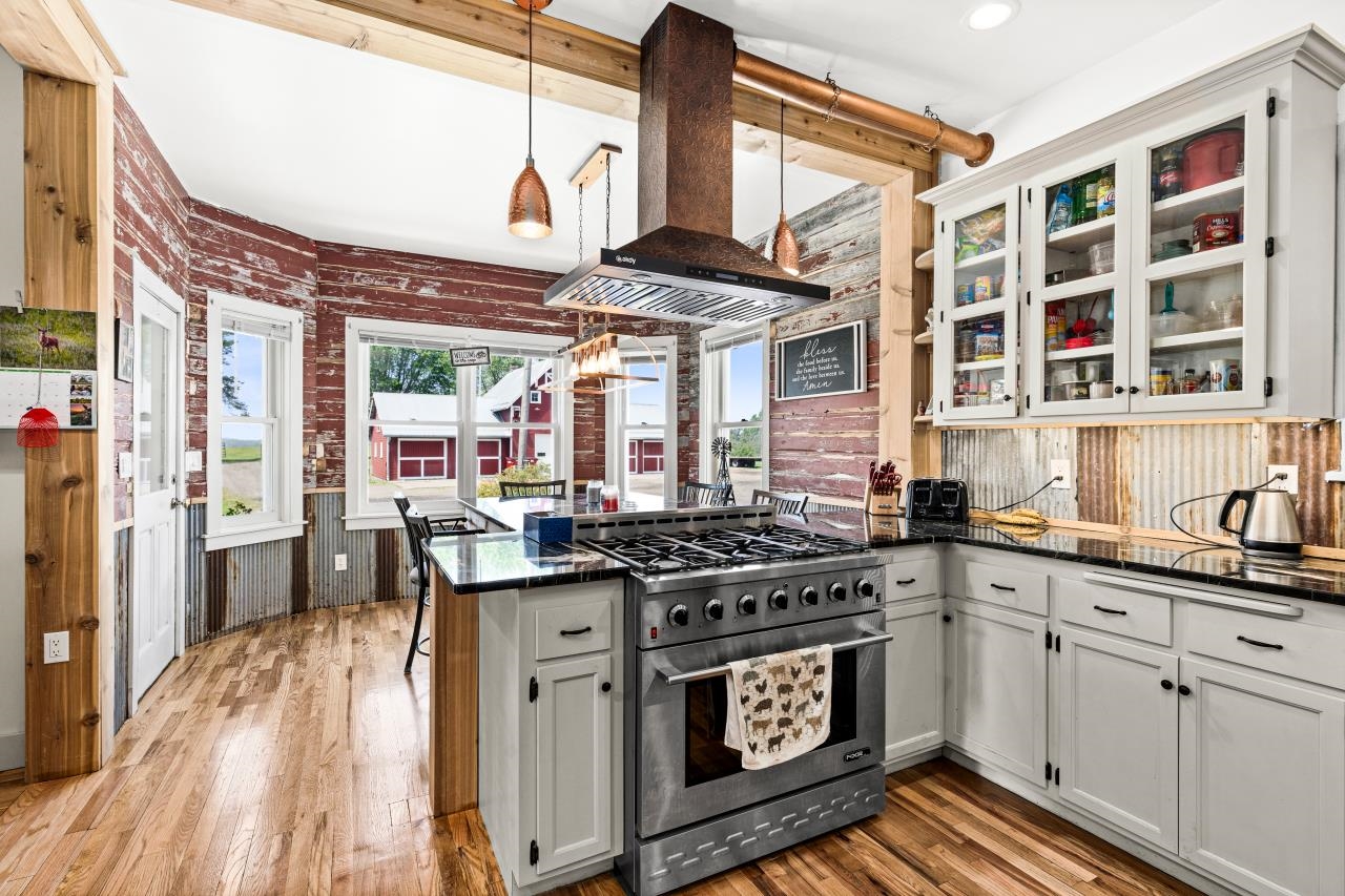 33415 Jackson Road Askov, MN 55704 - Photo 39 of 91 Kitchen featuring high end stove, island range hood, a peninsula, dark countertops, and light wood-style flooring