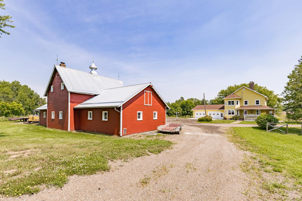 33415 Jackson Road Askov, MN 55704 - Photo 63 of 91 View of home's exterior with a chimney, a metal roof, gravel driveway, and a yard