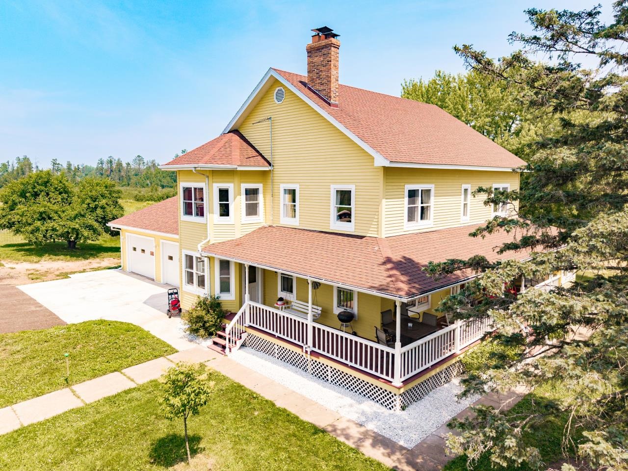 33415 Jackson Road Askov, MN 55704 - Photo 9 of 91 View of front of property with roof with shingles, concrete driveway, covered porch, and a front yard