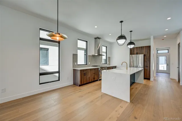 a large kitchen with stainless steel appliances kitchen island a large counter space and wooden floor