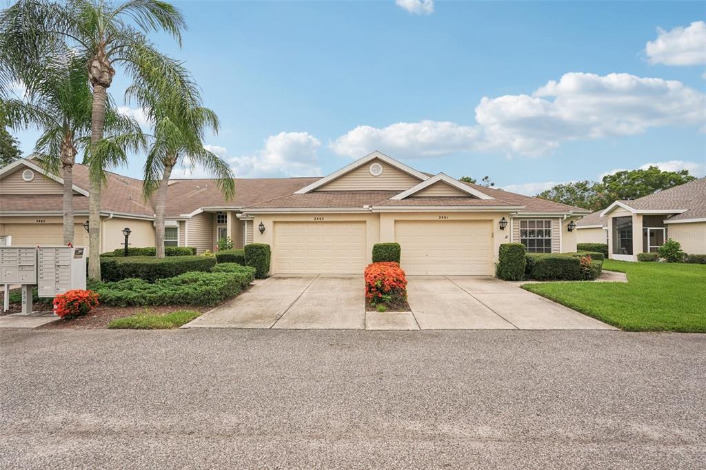 2461 Nantucket Harbor Loop Sun City Center, FL 33573 - Photo 44 of 47 a view of a white house with a small yard and palm trees