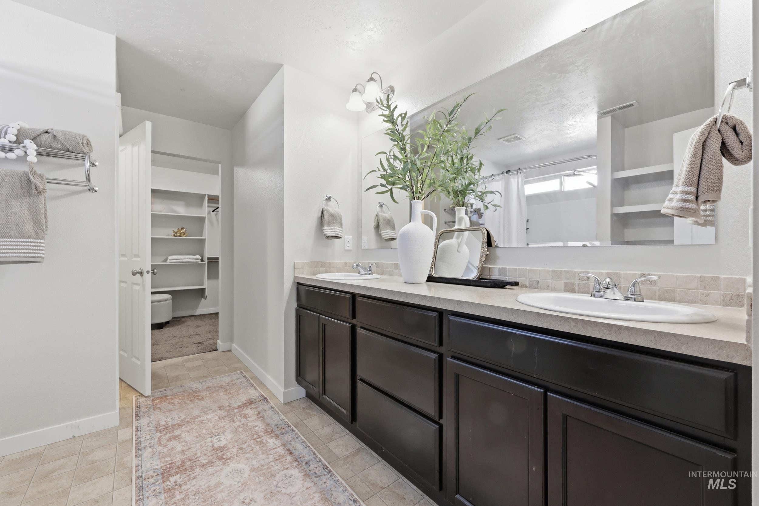 4855 South Chex Way Boise, ID 83709 - Photo 20 of 47 Dual vanity with dark wood cabinetry and integrated sinks